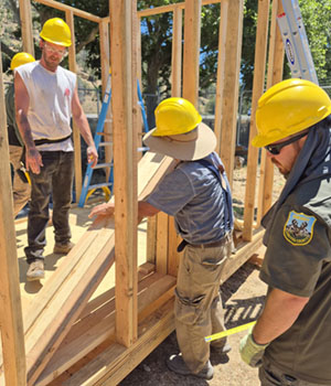 Three students framing shed
