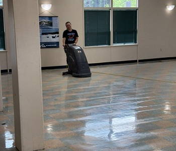 Custodian waxing floor in the John Mantle Student Center