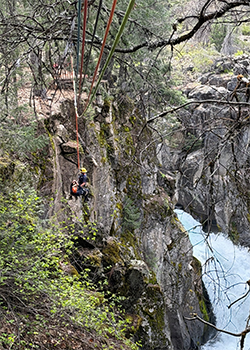 Firefighter rapelling down cliff