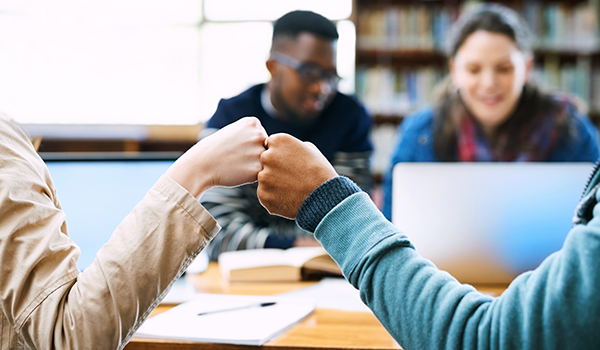 Two students fist bumping