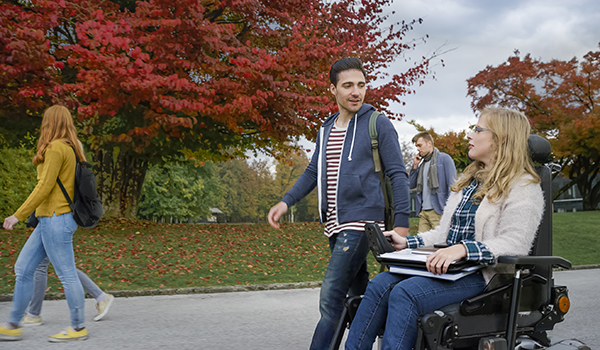 Student walking with student in wheelchair